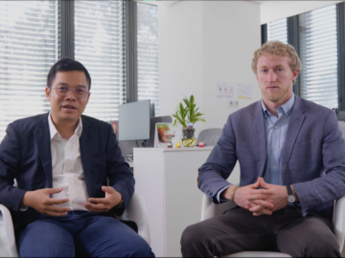 2 people sitting and 1 of them is talking