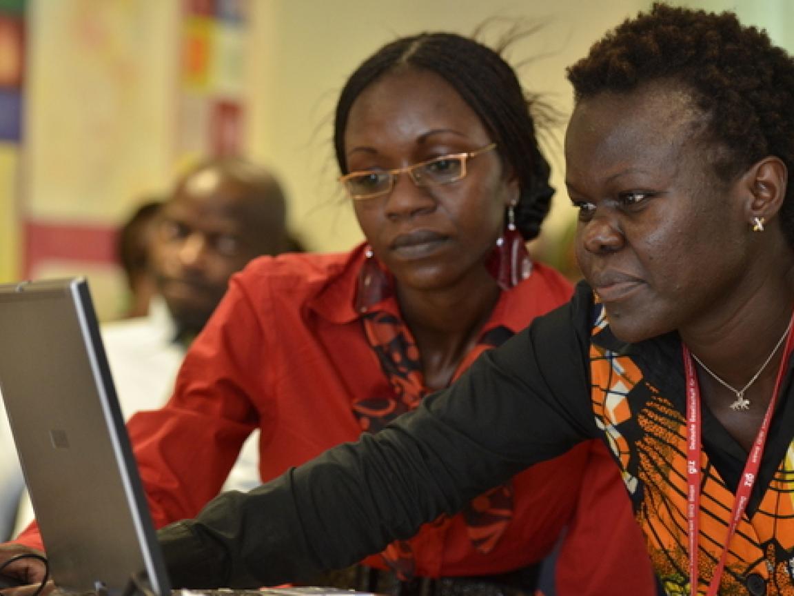 Zwei Personen, die gemeinsam auf einen Laptop-Monitor schauen