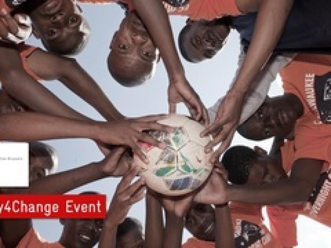 Viele Jungs halten einen Fußball zusammen in der Mitte