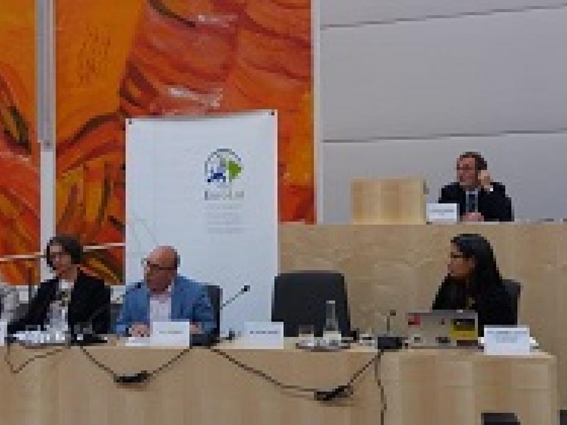 Personen sitzen auf einem Podium