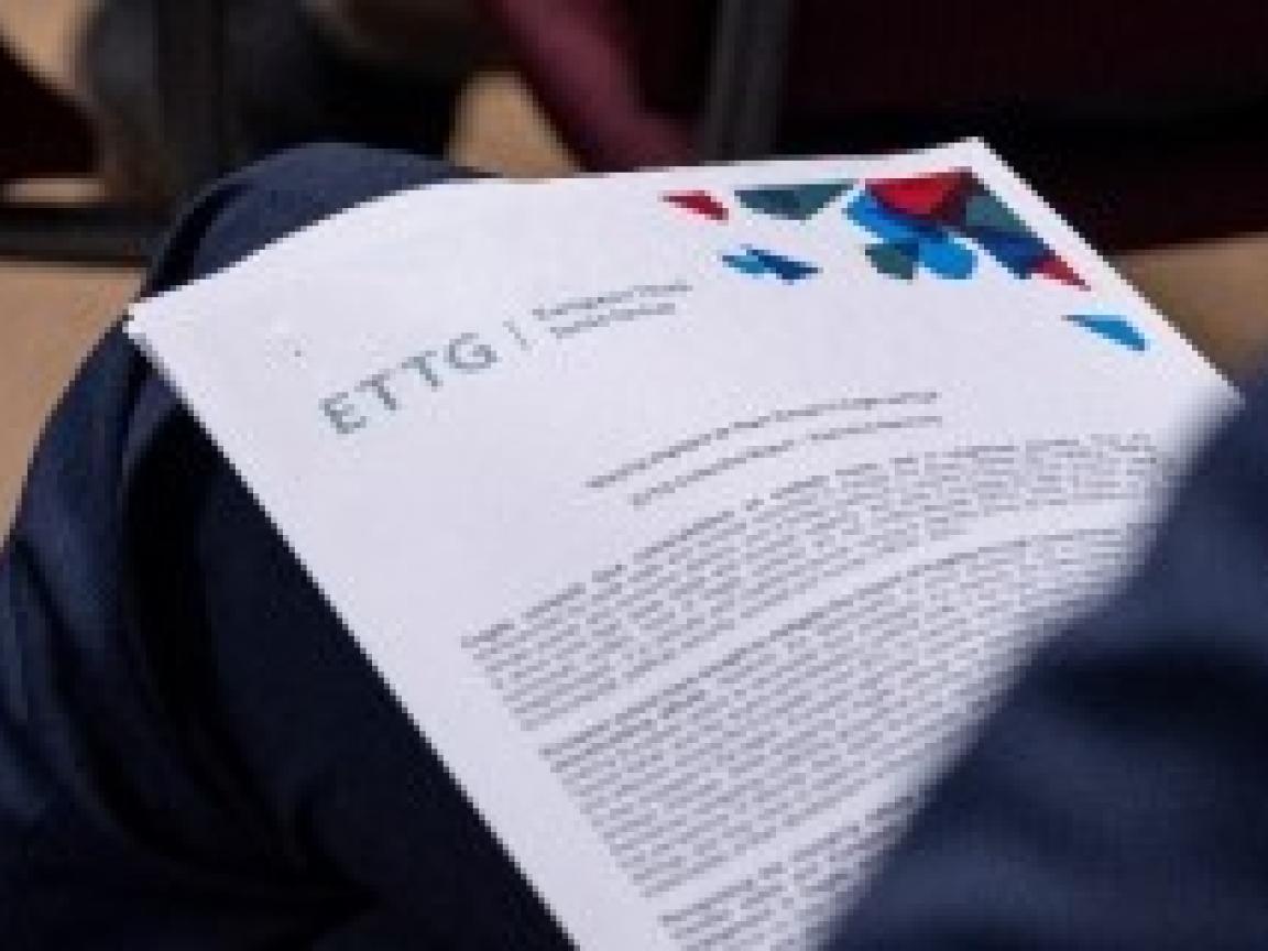 Mehrere Blatt Papiere liegen auf einem Bein