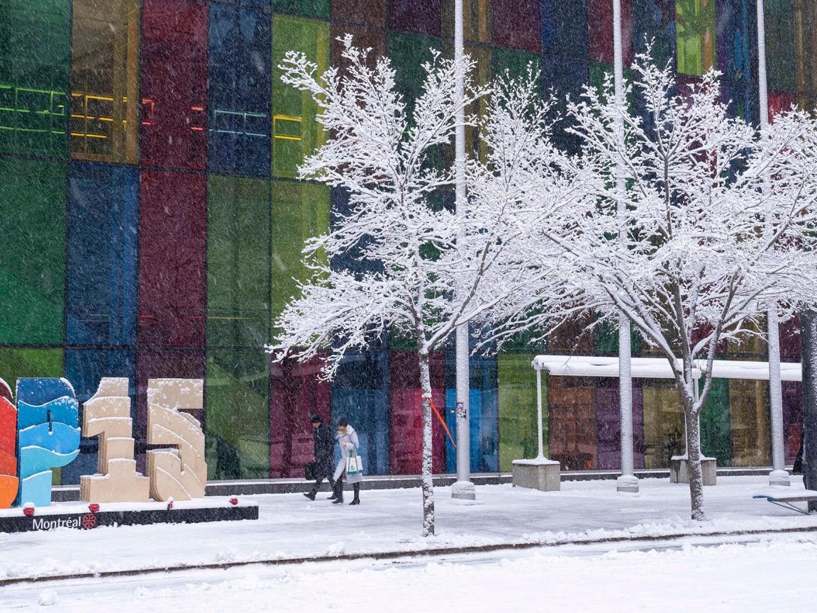 Bunte Häuserfront im Schnee mit Personen und Logo „COP15“