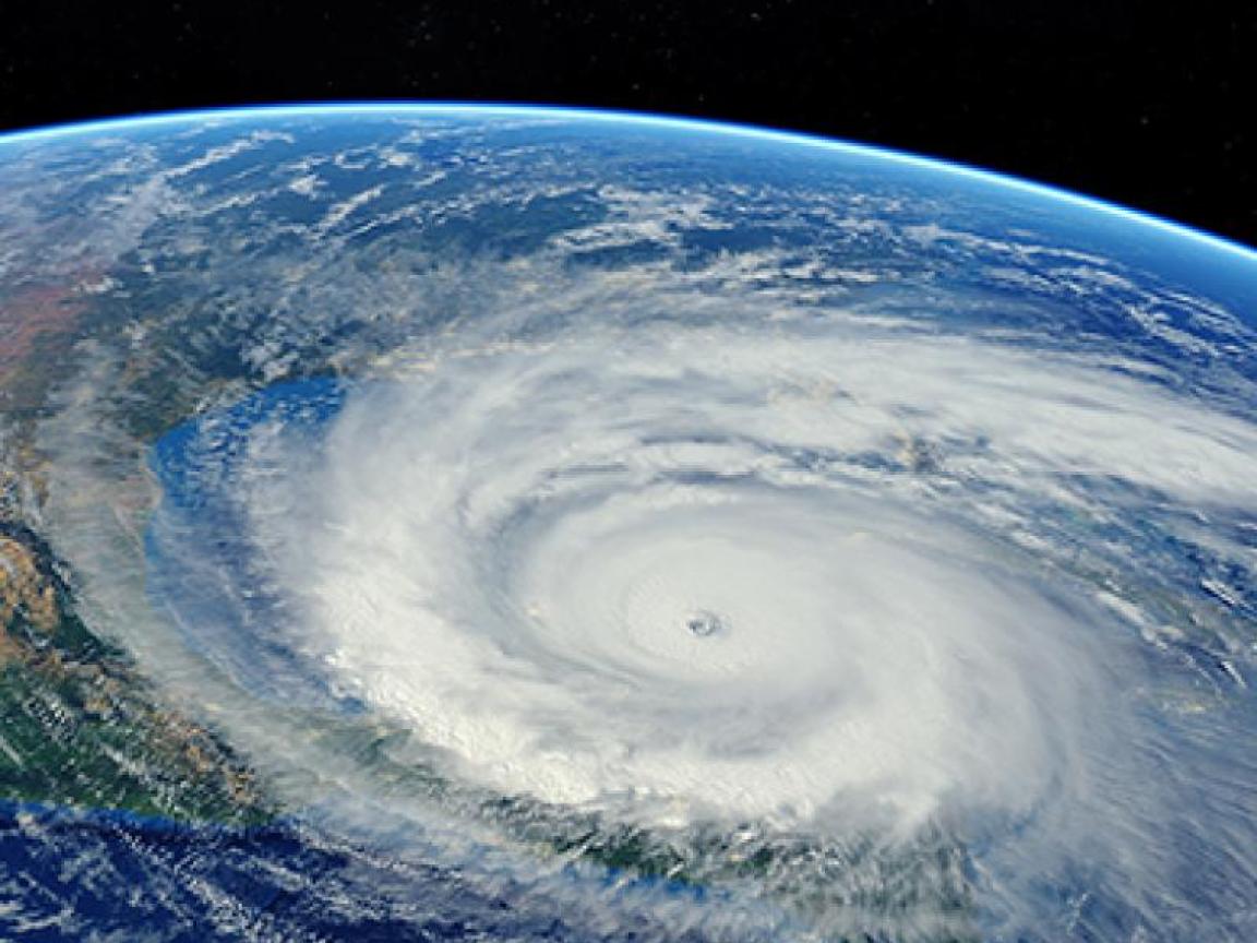 Satellitenfoto eines Hurrikans, der sich über den Ozean einem Kontinent nähert. Der Hintergrund ist schwarz und zeigt die Erde aus der Weltraumperspektive