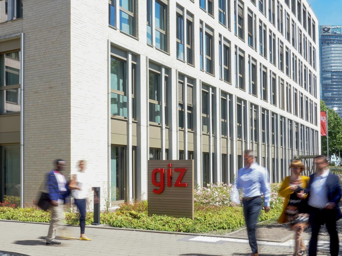 Menschen in Bewegung vor dem Gebäude der GIZ