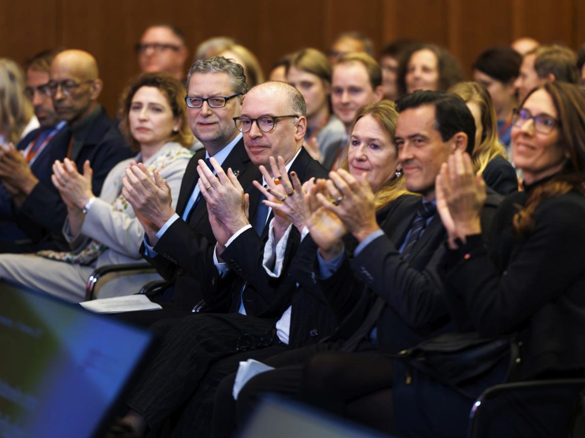 Several persons sitting in a row, clapping