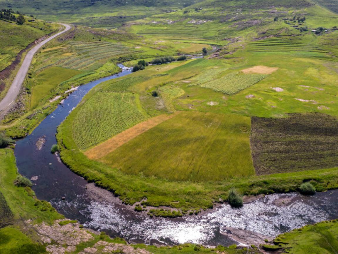 A vast green landscape in Lesoto, through which a large river meanders.