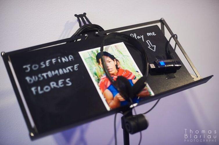 Auf einem Notenhalter ist ein Bild von einer Frau zu sehen. Darüber liegen Kopfhörer