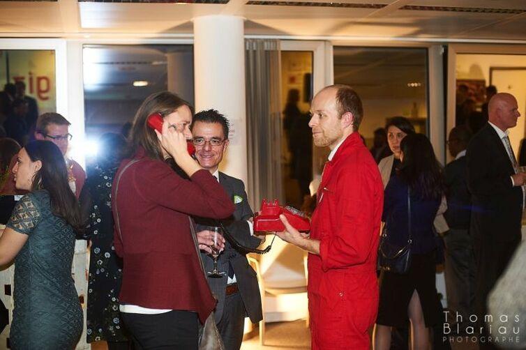 Eine weitere Frau hält den Hörer eines roten Telefons in der Hand