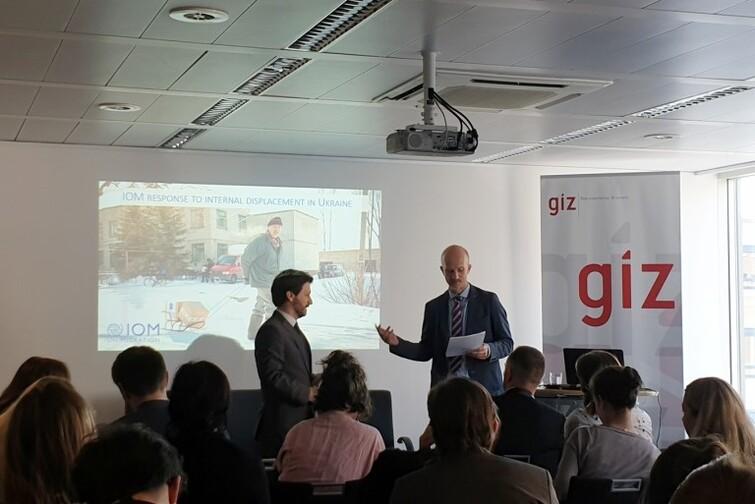 Zwei Männer stehen vor einem Publikum