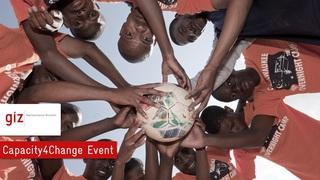 Viele Jungs halten einen Fußball zusammen in der Mitte