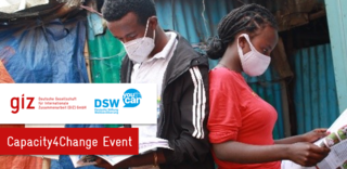 Zwei Personen mit einer Gesichtsmaske stehen Rücken an Rücken