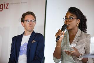 Eine Frau hält ein Mikrofon in der Hand. Neben ihr steht ein Mann