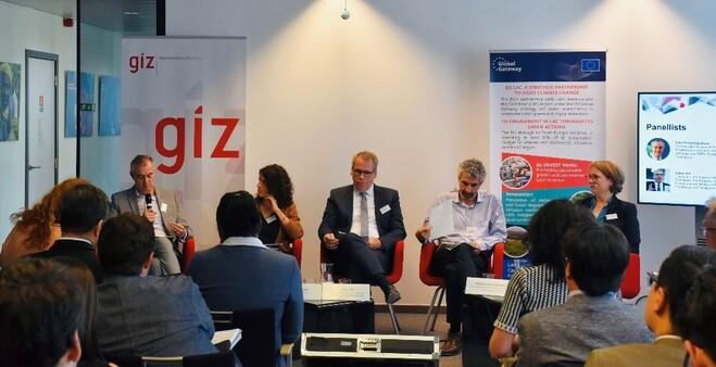 Personen sitzen vor einem Publikum