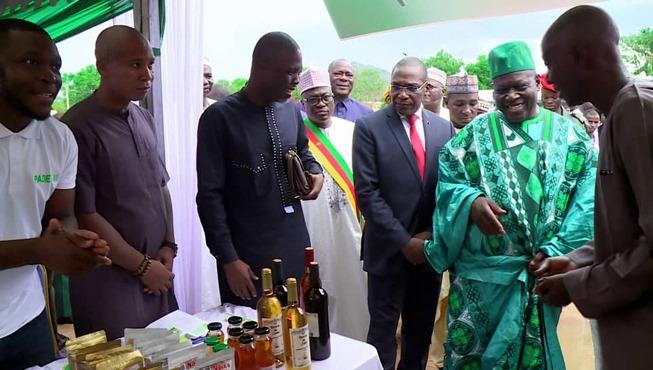 Viele Personen stehen um einen Tisch herum auf dem Flaschen stehen