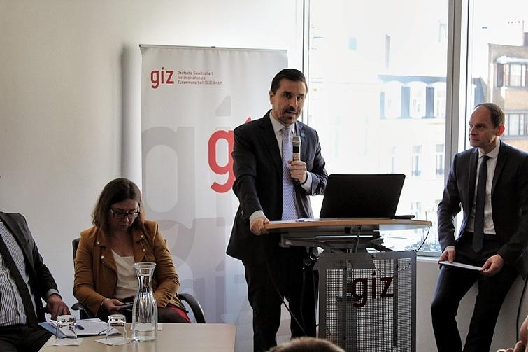 Mann steht an einem Pult und hält ein Mikrofon