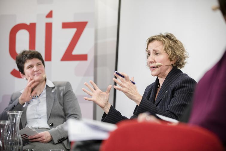 Zwei Frauen sitzen auf Stühlen nebeneinander