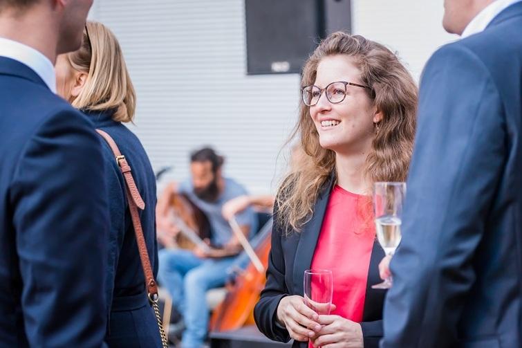 Frau mit Brille hält ein leeres Sektglas