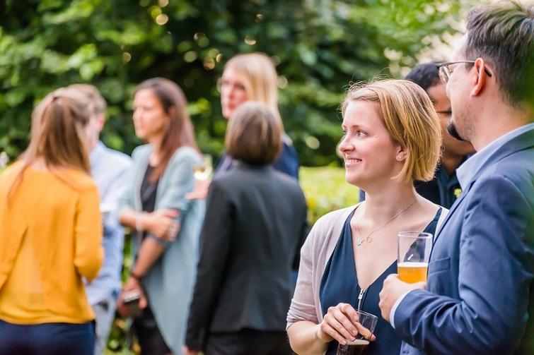Personen stehen draussen und halten ihre Gläser