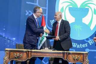 Two men shaking hands over an signed agreement
