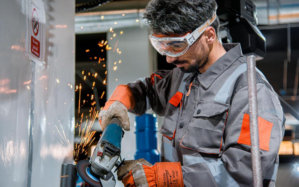 Ein Mann arbeitet mit einem Winkelschleifer