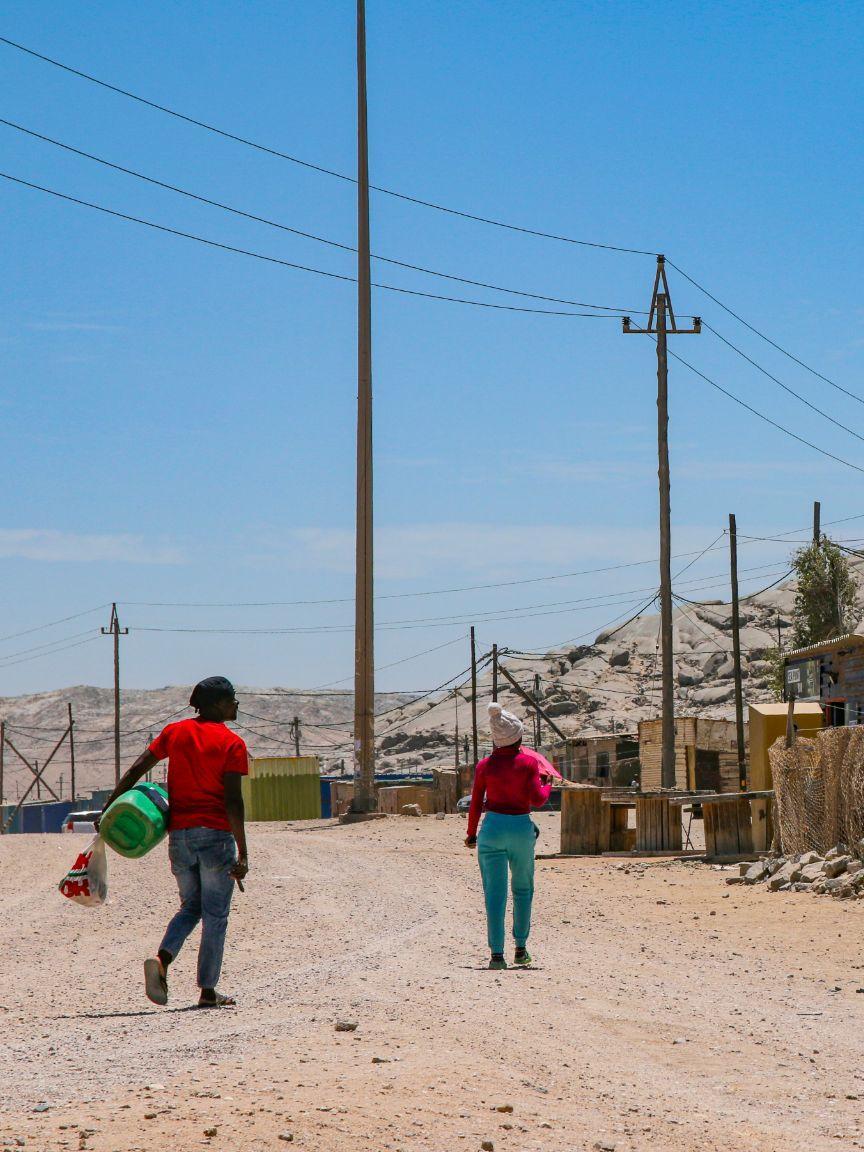 Two women are standing on a path.