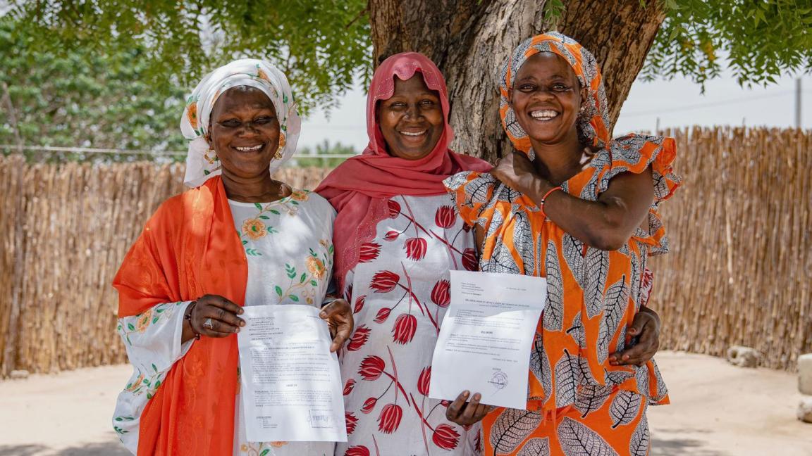 Group photo with three women, two holding up a certificate