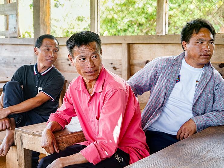 Three men are sitting at tables.