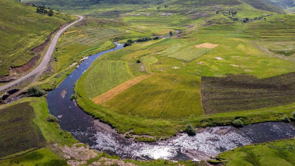 A vast green landscape in Lesoto, through which a large river meanders.