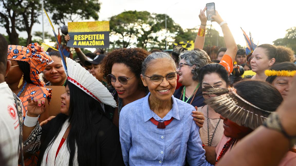Crowd of people in various traditional outfits participating in an Amazon protest.