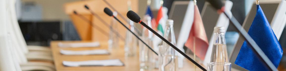 Table de conférence avec micros et drapeaux nationaux