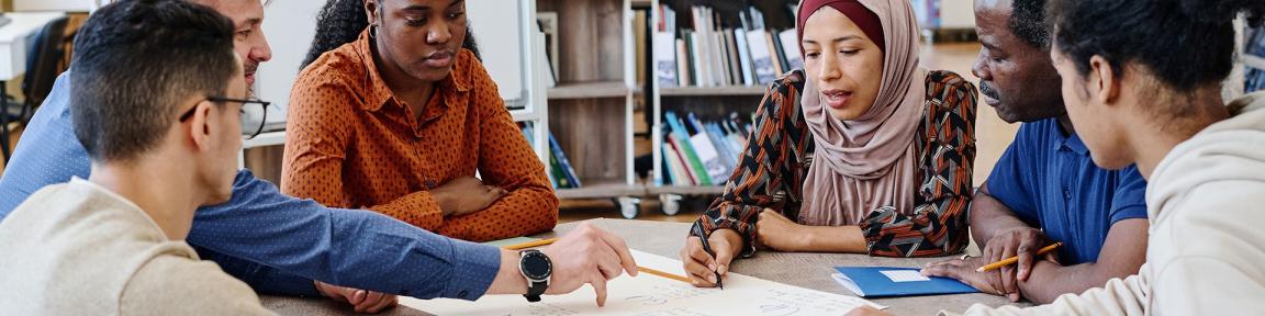 Des personnes de différentes nationalités discutent autour d'une table.