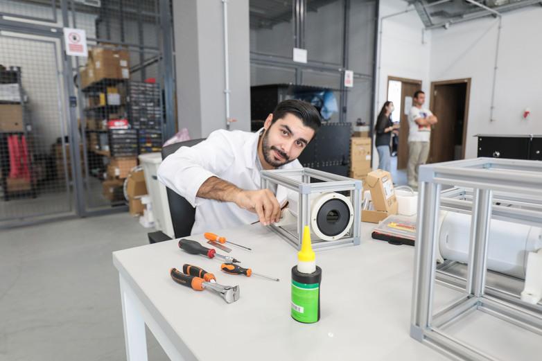 Un homme intervient sur un composant d’ordinateur dans une entreprise informatique.