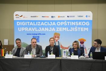 Grupa ljudi sjedi ispred ilustracije o digitalizaciji ekonomije u Evropskoj uniji.