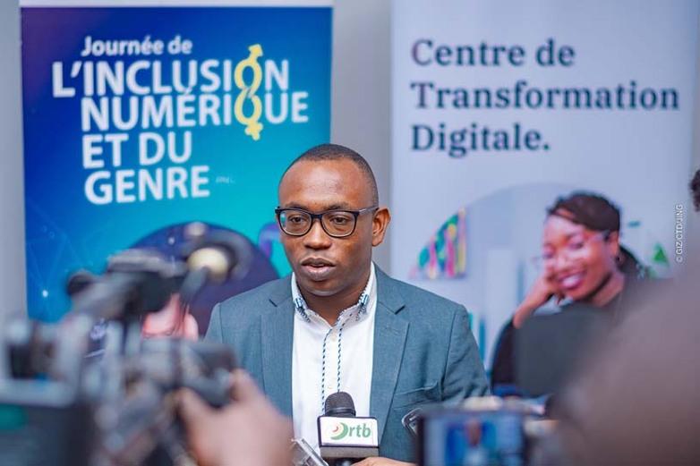 Ein Mann hält ein Mikrofon und spricht in eine Kamera bei einer Veranstaltung zum Thema digitale Inklusion. Copyright: GIZ