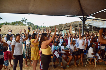 Mulheres apontam com as mãos durante uma votação.