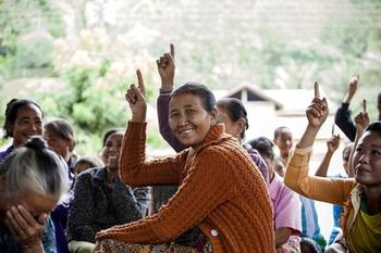 Women sitting together; some are pointing up. Copyright: GIZ Laos