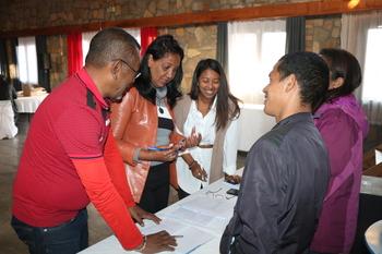 Five people are in conversation with documents in front of them.