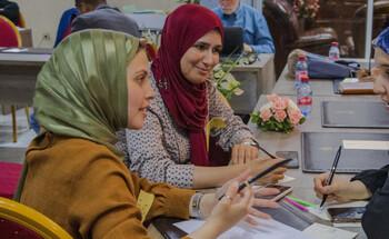 Drei Finalistinnen des Green Startup Wettbewerbs unterhalten sich bei einer Fortbildung zu Unternehmertum.