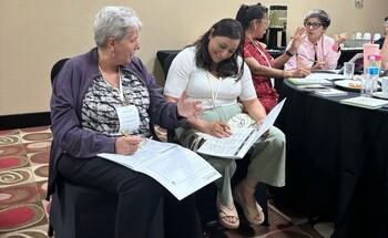 Participants collaborating in small groups during a workshop on technical cooperation in Mexico, reviewing documents and taking notes.