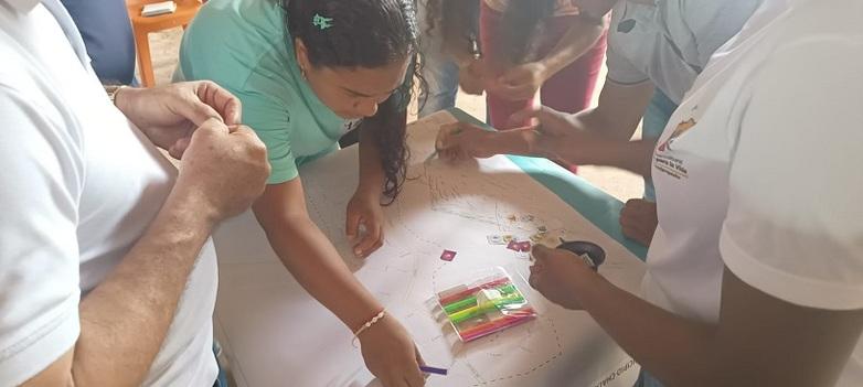 Two women in a group drawing a map.