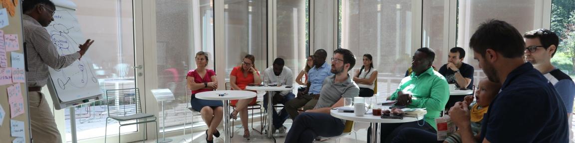 Menschen sitzen bei einem Training zusammen.