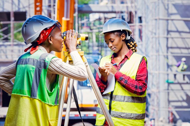 Zwei junge Frauen arbeiten auf einer Baustelle