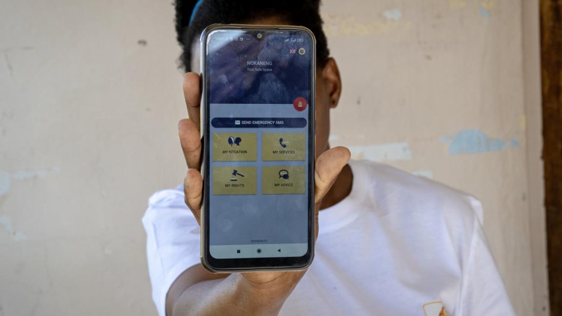 A person shows a mobile phone screen with the Nokaneng app open.App geöffnet ist.
