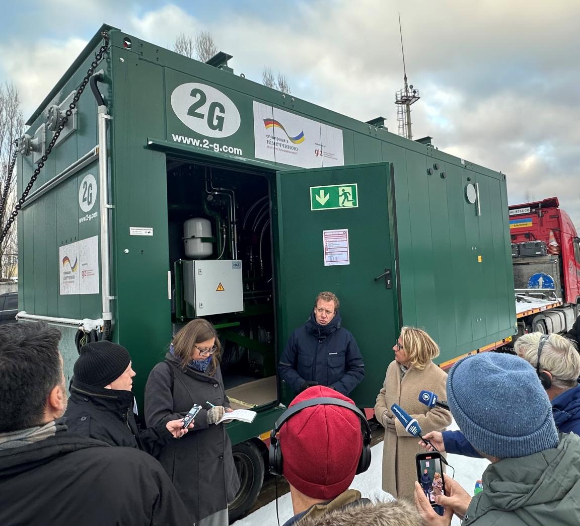 Svenja Schulze und Daniel Busche sprechen bei einer Auslieferung eines Heizkraftwerks mit Journalist*innen.