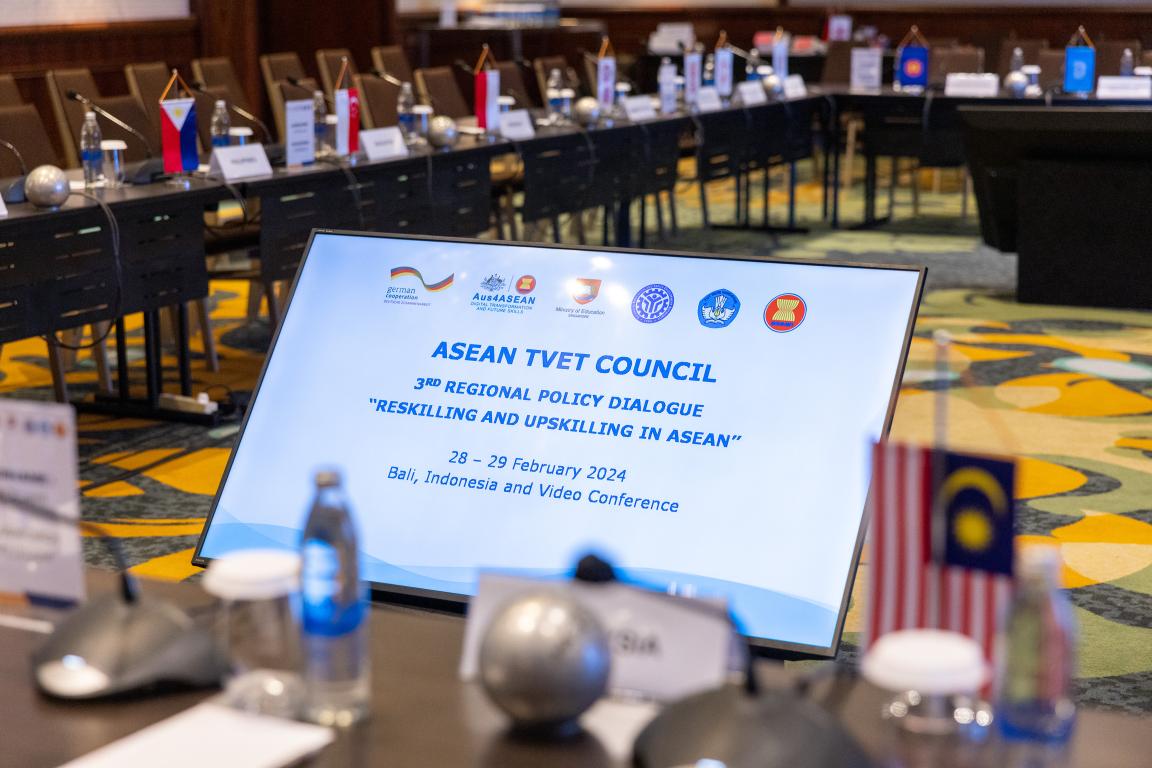 Conference room with a screen and flags from Southeast Asia.
