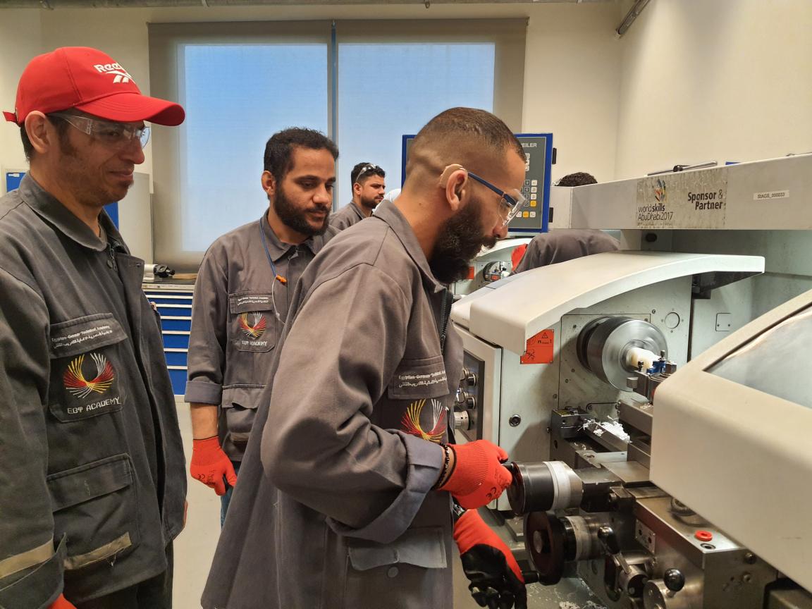 Men are working on a machine in a workshop.