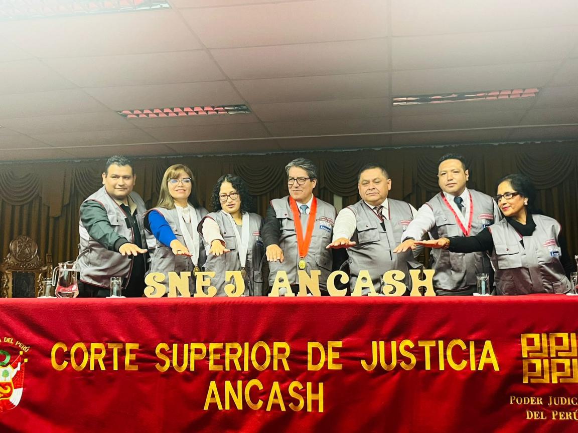 Varias personas frente a una mesa sobre la que figura el texto “SNEJ ANCASH”.