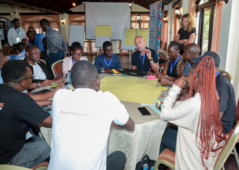 Teilnehmende eines Workshops sitzen an einem Tisch zusammen während des Blue Economy Innovation and Investment Summit in Mombasa, Kenia. 