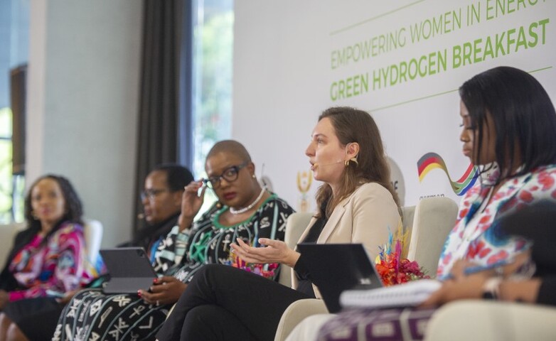 Podiumsdiskussion bei der Veranstaltung „Empowering Women in Energy: Green Hydrogen Breakfast“ mit fünf Frauen im Gespräch, im Hintergrund der Titel der Veranstaltung sowie Logos von Partnern.