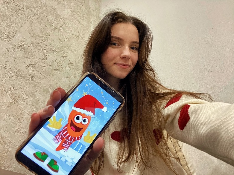 Anna Nehrii hält ein Smartphone mit der geöffneten App „Möhrchen“.